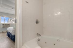 a bath tub in a bathroom with a bedroom at Mt Royal Motel in Old Orchard Beach