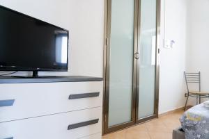 uma sala de estar com televisão numa cómoda em Casarossa em Pachino