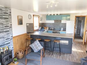 a kitchen with a counter and stools in a room at Reuben's Highland Retreat - Arisaig in Arisaig