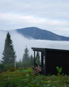 a house on a hill with a view of a foggy mountain at Chilloutzonе - Будинок з безкоштовним джакузі та кінотеатром in Slavske