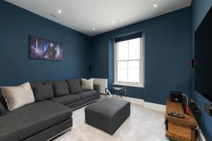 a living room with a couch and blue walls at Luxury home by the harbour in Ilfracombe