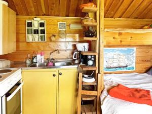 a small kitchen with a sink and a bed in a cabin at Holiday home LIDKÖPING IX in Tallbacken