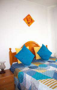 a bedroom with a bed with blue and yellow pillows at Casa Maria in Albufeira