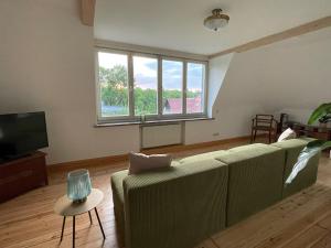 ワイマールにあるKulturgenuss am Goethewanderwegのソファとテレビのあるリビングルーム