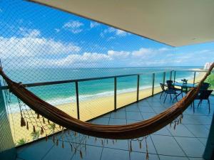 een hangmat op een balkon met uitzicht op het strand bij Ed. Crystal Residence in Vila Velha