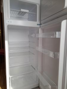 an empty refrigerator with its door open in a kitchen at Oaza in Ražanac