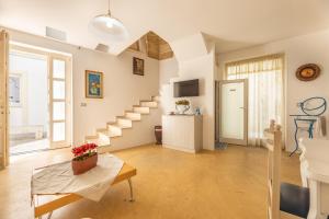 Sala de estar con escaleras y mesa en Dimora il Castello, en Racale