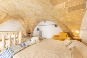 Cama en habitación con techo de piedra en Dimora il Castello, en Racale