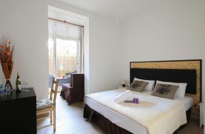 
a hotel room with a bed, chair, table and window at Hostal Balkonis in Barcelona
