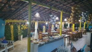 a restaurant with a table with food and balloons at Pousada Tropical Araçatiba in Praia de Araçatiba