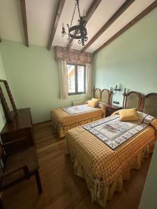 a room with two beds and a table and a window at Lar do Pilís in Ourense