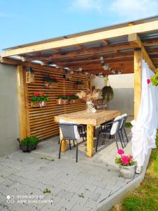 a wooden table and chairs on a patio at Chalúpka Anit 