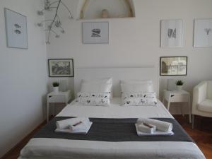 a white bedroom with a large bed with two towels at St. Lazarus Room in Dubrovnik