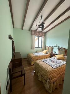 Habitación con 2 camas y una silla. en Lar do Pilís en Ourense