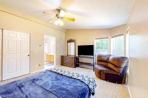 um quarto com uma cama, uma cadeira e uma televisão em ArrowLeaf Cabin em Bremerton