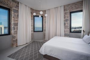 1 Schlafzimmer mit einem weißen Bett und 2 Fenstern in der Unterkunft Architect's seafront flat in Split