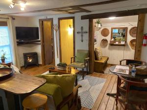 ein Wohnzimmer mit einem Tisch und einem Kamin in der Unterkunft New Listing! Convenient Cottage - Hot Tub, 4 Minutes to Dahlonega in Dahlonega