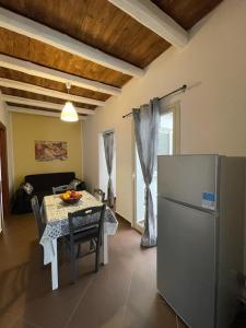ein Wohnzimmer mit einem Tisch und einem Kühlschrank in der Unterkunft Sweet Life in Palermo
