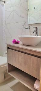 a bathroom with a sink and a mirror and a tub at Colorful Garden House in Providencia