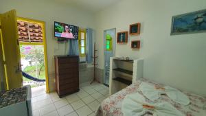 a bedroom with a bed and a flat screen tv at Pousada Tropical Araçatiba in Praia de Araçatiba