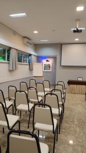 una sala de conferencias con sillas y una pantalla de proyección en New Life Piracicaba by Atlantica en Piracicaba