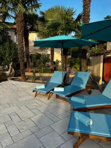 zwei blaue Stühle und ein Regenschirm auf einer Terrasse in der Unterkunft Holiday House Serenity in Malinska