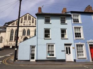 uma casa azul numa rua com um edifício em Ty Cornel em Aberdyfi