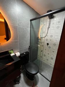y baño con ducha y aseo negro. en Milos Hotel Icaraizinho, en Icaraí