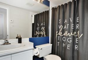 a bathroom with a toilet and a shower curtain at 26#52 Chemin du Hameau (studio) in Stoneham