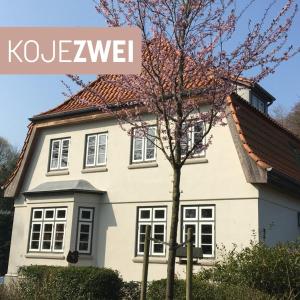 una casa blanca con un cartel que dice Kokovlez en Koje 2, en Glücksburg
