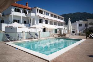 a large swimming pool in front of a building at Kostas Beach Apartments in Agios Gordios