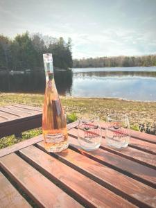 a bottle and two glasses sitting on a picnic table at Muskoka Escape in Port Carling