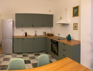 eine Küche mit grünen Schränken und grünen Stühlen in der Unterkunft Lo Studio in Pisa
