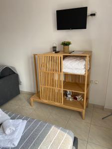 a room with a tv on a wall with a crib at K & G Central Apartments Fira in Fira