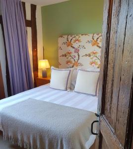 a bedroom with a bed with a floral headboard at La Venelle Saint Jean in Honfleur +39 photos