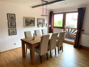 a dining room with a wooden table and white chairs at Ferienwohnung Meridiana in Tuntenhausen