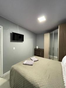 um quarto com uma cama e uma televisão de ecrã plano em Edícula Cambará em Cambará
