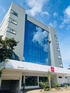 un edificio de oficinas con una fachada de cristal azul en Atrium Express Hotels en Parauapebas