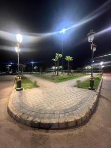 a park at night with two lights on a sidewalk at PERLA NOUACEUR AéROPORT MOHAMMED V in Nouaceur