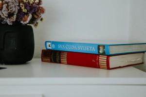 dos libros sentados en una mesa junto a un jarrón en Kuća za odmor ''FURLAN'' en Gospić