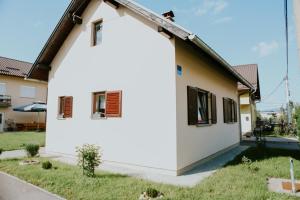 una casa blanca con una escalera a un lado en Kuća za odmor ''FURLAN'' en Gospić