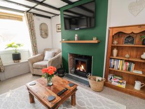 a living room with a fireplace and a couch at CurLi Cottage in Bideford