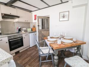 a kitchen with a wooden table with plates on it at CurLi Cottage in Bideford