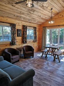 - un salon avec une table et des chaises dans l'établissement The Pines Cottage Resort, à Oxtongue Lake