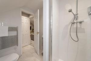 a white bathroom with a shower and a toilet at Hamble Retreat Studios and Lodge in Warsash