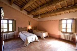 a bedroom with two beds and two windows at Villa Il Cigno in Brisighella +42 photos