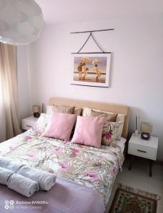 um quarto com uma cama com almofadas cor-de-rosa em Apartman Bella Vista em Golubac
