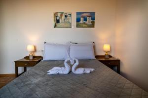 dos toallas de cisne en una cama con dos lámparas en Mayia Sunset sea front house Gouves Heraklion en Gouves