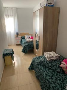 Habitación pequeña con 2 camas y espejo. en Apartamentos Wei en Grao de Castellón