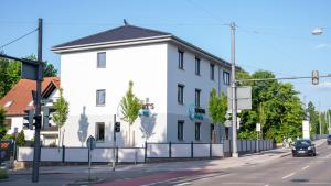 un edificio blanco al lado de una calle en Henrys Sleeping am Augsburger Eiskanal en Augsburg